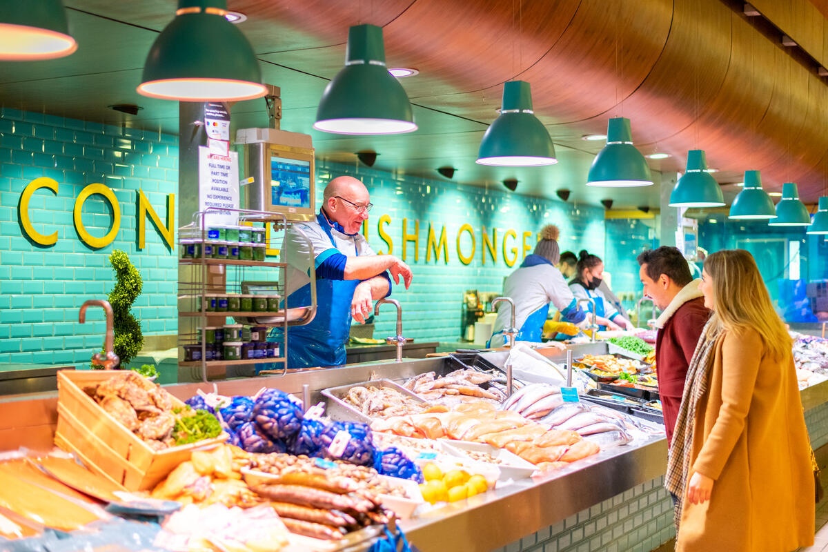 Fishmonger Pat O'Connell talking with customers at K. O'Connell's in Cork's English Market.